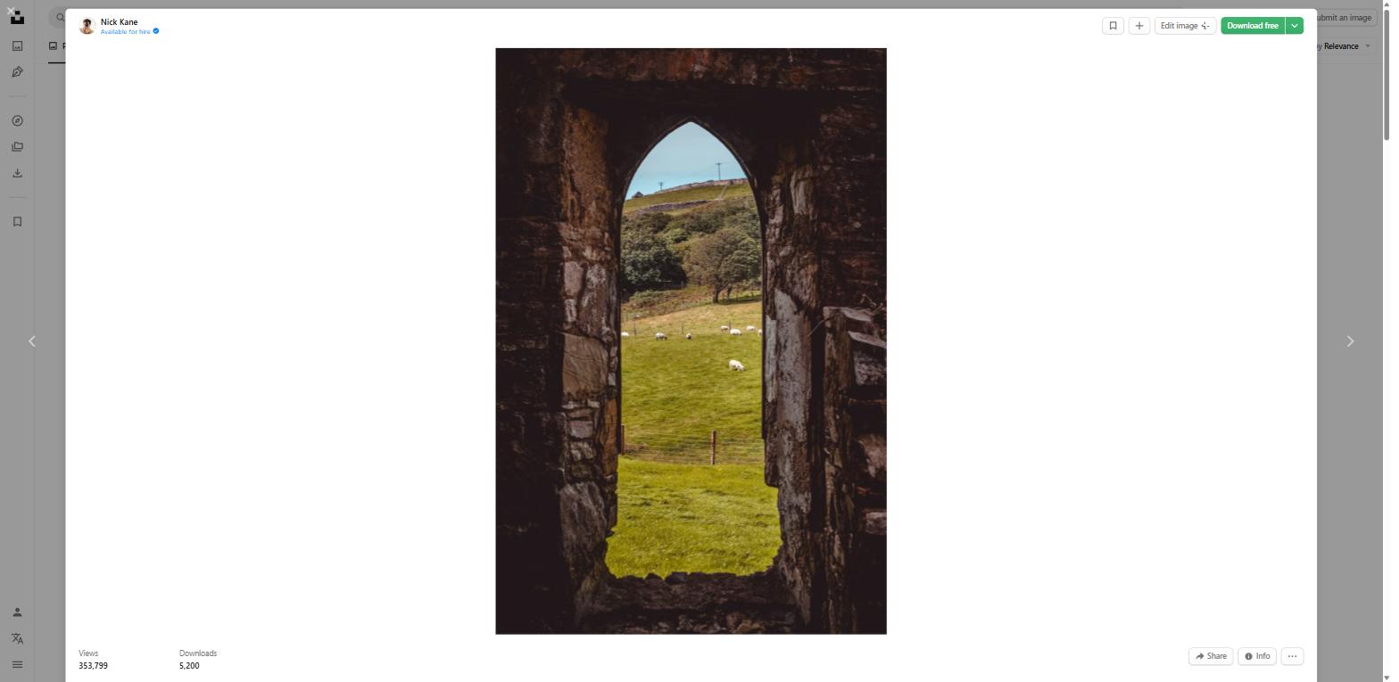 Ancient stone archway in Ireland with sheep grazing in the countryside beyond